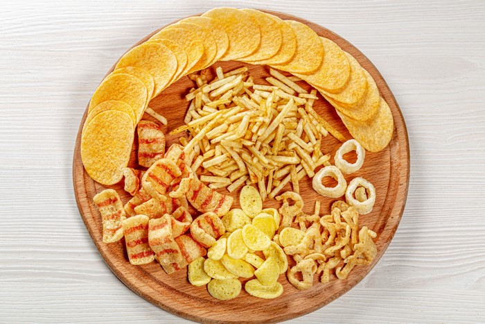 Assortment of chips and fries on a cutting board