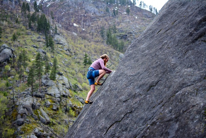 Woman rock climbing on a large boulder