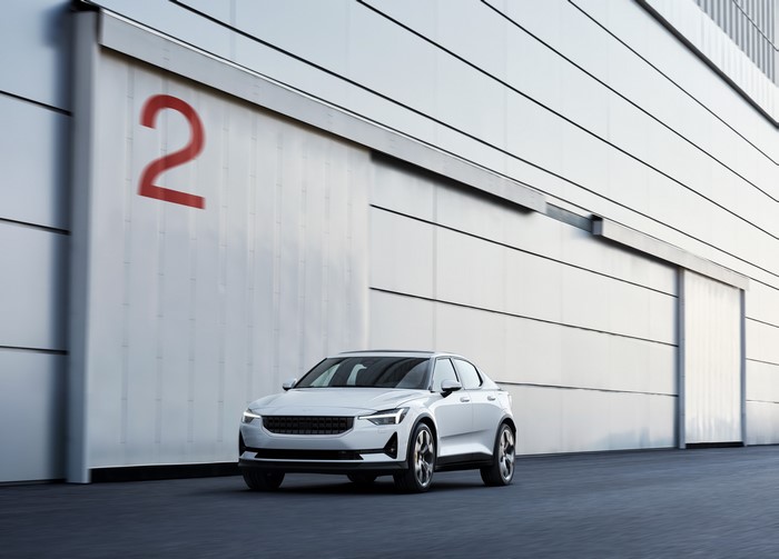 White Polestar 2 parked in front of a building with a large red 2