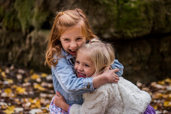 Two little girls hugging and laughing