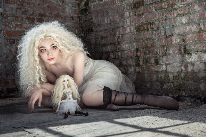 Blonde girl with curly hair and a doll