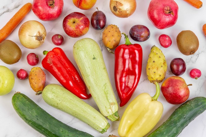 Assortment of fresh fruits and vegetables on a marble surface