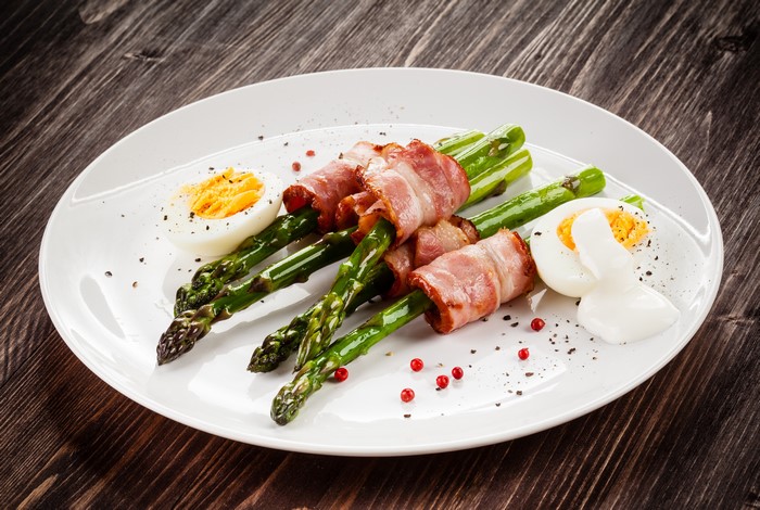 Asparagus wrapped in bacon with boiled eggs