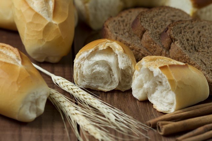 Bread rolls, sliced bread, wheat ears, and cinnamon sticks