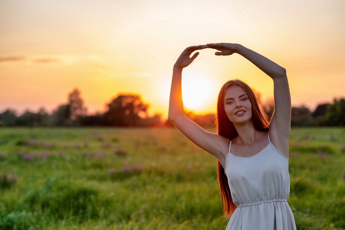 Woman Posing by Sunset in a Green Field
