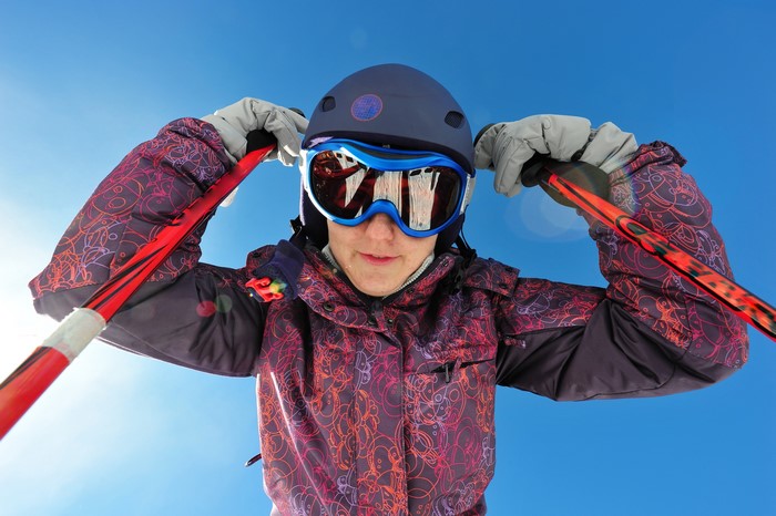 Person in Ski Gear Adjusting Goggles and Holding Poles