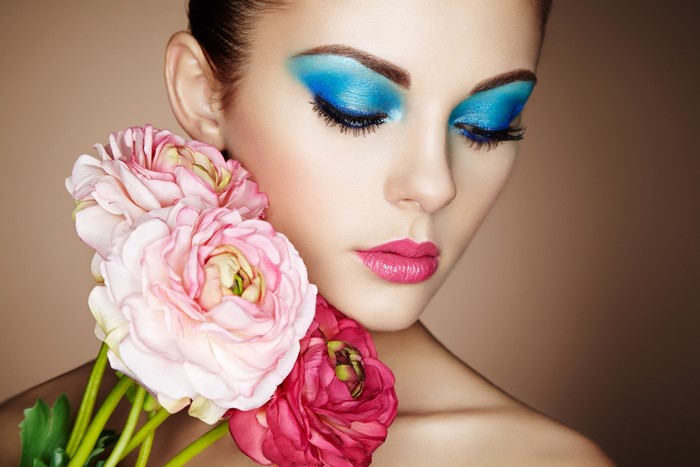 Woman with blue eyeshadow and pink flowers