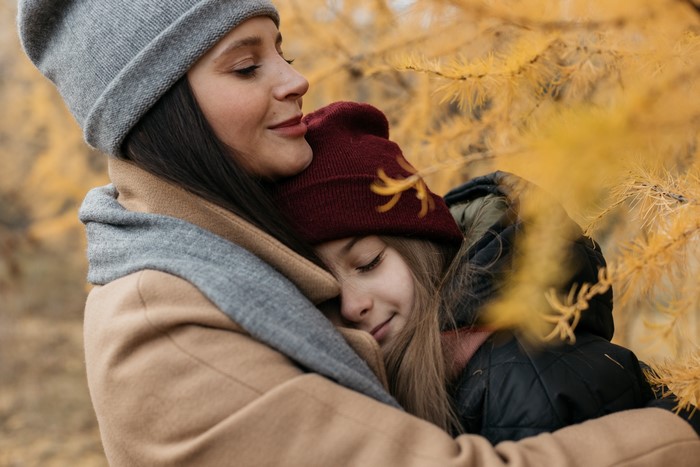Mother and daughter hugging in autumn