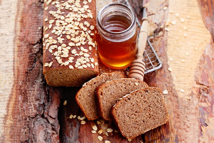 Bread with honey and oats on wood