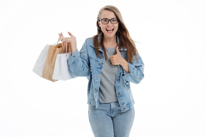 Woman with shopping bags giving a thumbs up