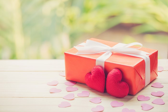 Red gift box with white ribbon and hearts