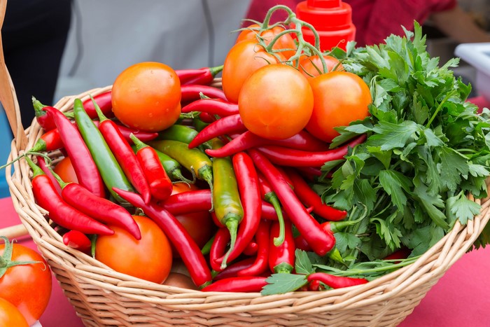 Wicker basket with tomatoes, chili peppers, and parsley