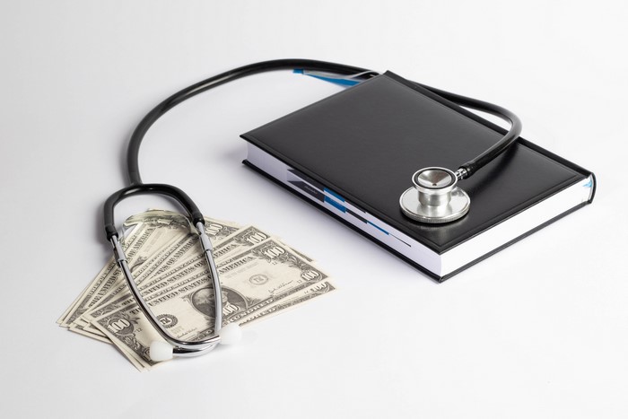Stethoscope on Notepad with US Dollar Bills