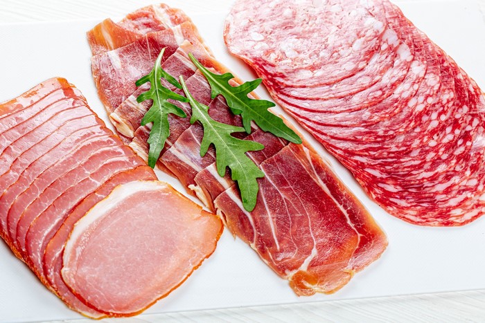 Sliced Ham, Prosciutto, and Salami on White Background