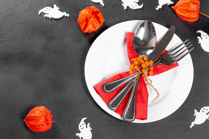Halloween table setting with plate, cutlery, and physalis