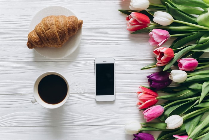 Croissant, Coffee, Tulips, and Smartphone on White Table