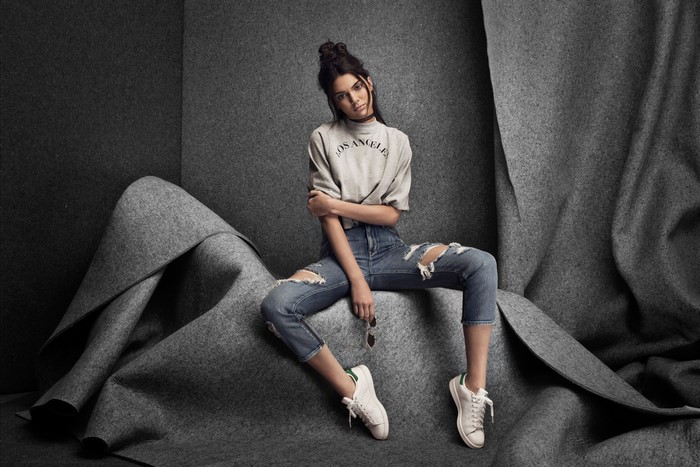 Kendall Jenner sitting in ripped jeans