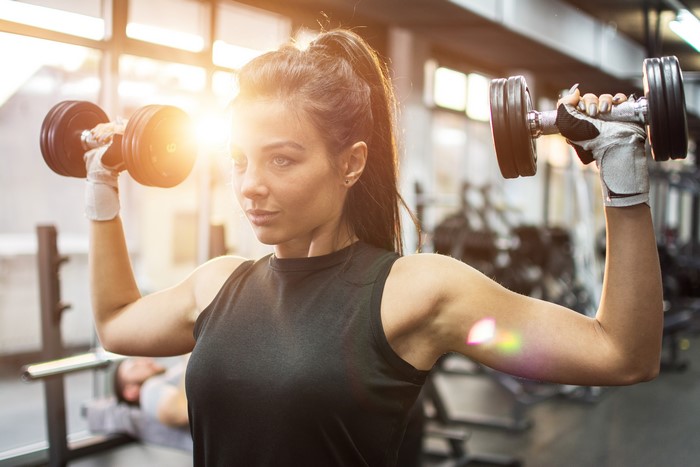 Woman lifting dumbbells in a gym
