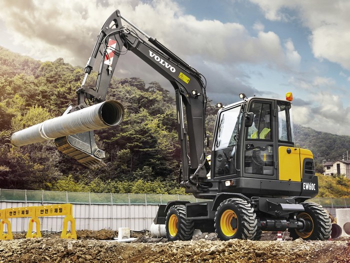 Volvo EW60C excavator lifting a large pipe