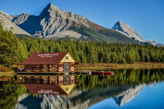 Maligne Lake Boathouse with Mountains and Forest Reflection