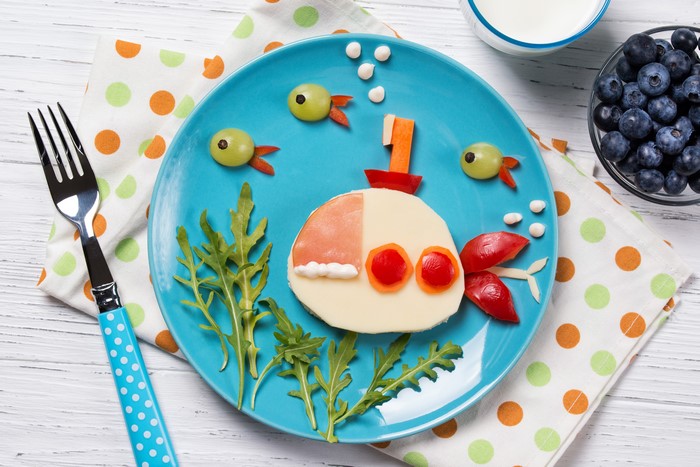 Creative submarine-themed food art on a blue plate
