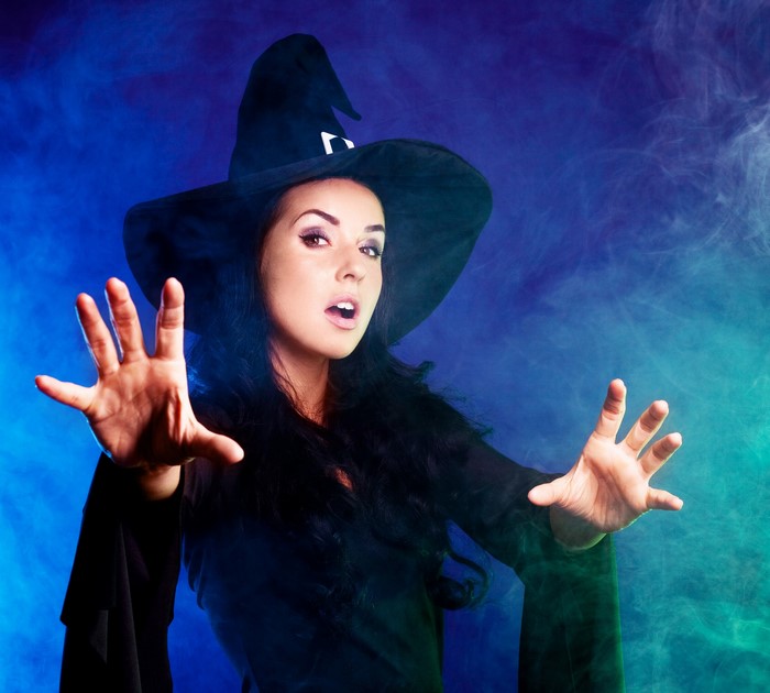 Woman in witch hat casting a spell