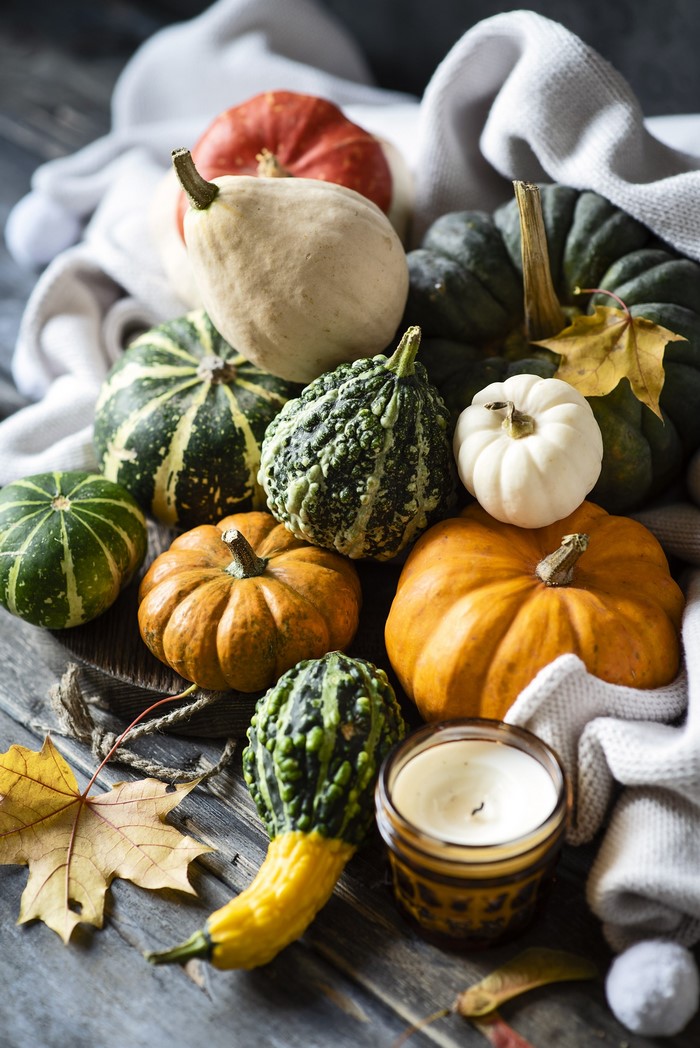 Autumn pumpkins and candle with fall foliage
