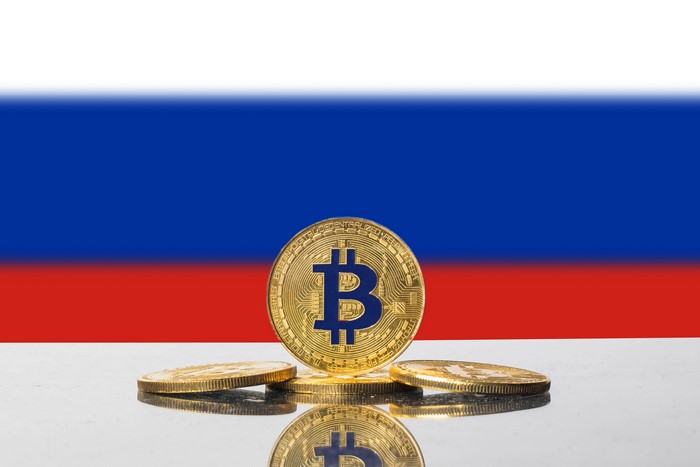 Bitcoin coins on Russian flag background