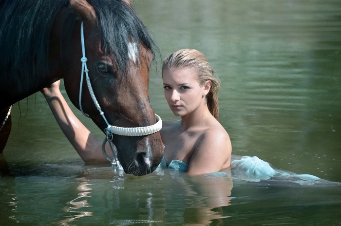 Blonde girl and horse in water