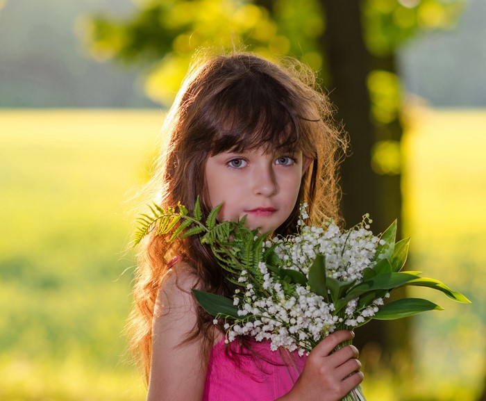 Young girl holding lilies of the valley bouquet