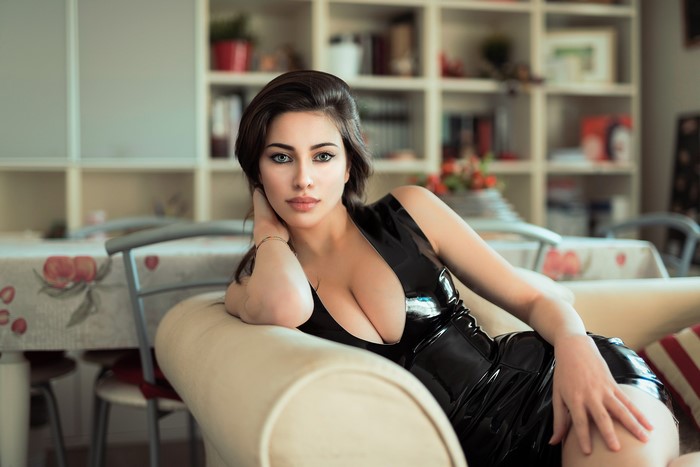 Woman in black dress posing on a couch