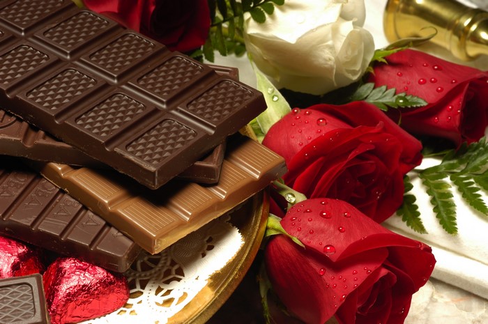 Chocolate bars and red roses with water droplets