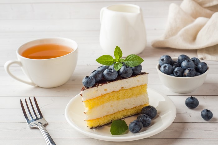 Slice of cake with blueberries and tea