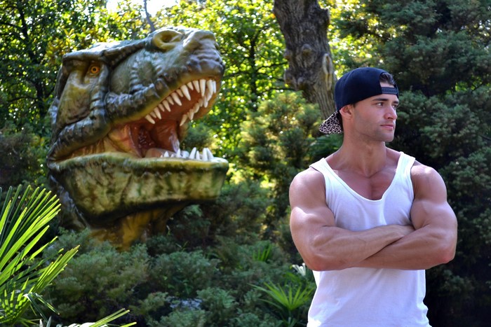 Man in singlet with dinosaur sculpture