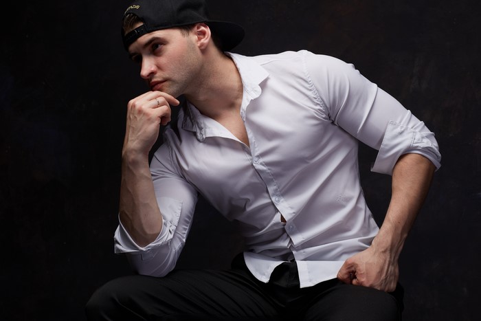 Man in white shirt and baseball cap sitting