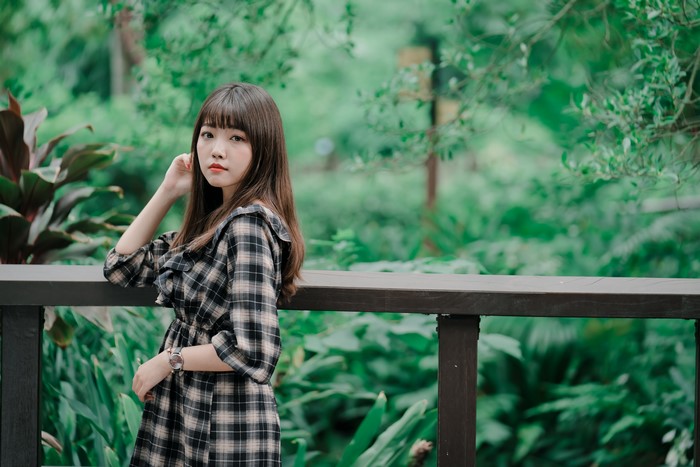 Asian woman in plaid dress posing outdoors