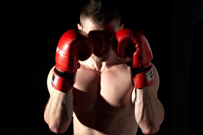 Man in red boxing gloves on black background