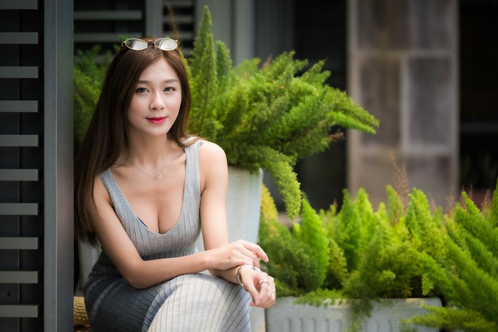 4K Portrait of Smiling Woman in Grey Dress Sitting