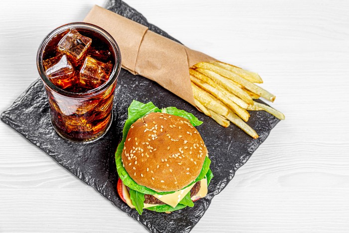 Hamburger, French fries, and Coca-Cola on a slate tray