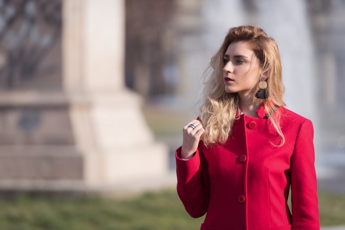 Blonde girl in red coat with large earrings