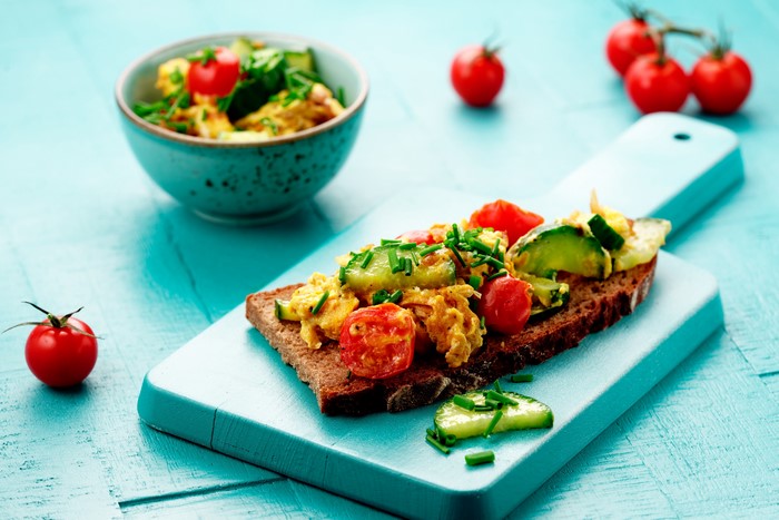 Scrambled eggs on toast with vegetables