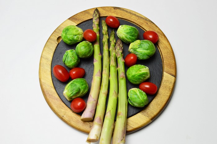 Asparagus, Brussels Sprouts, and Tomatoes on Cutting Board