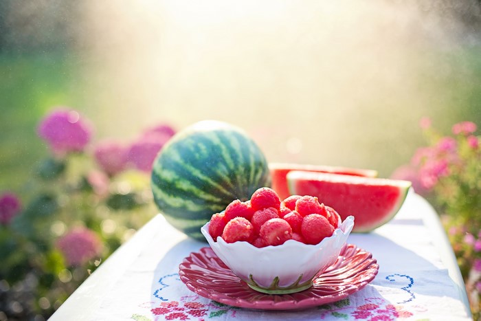 Watermelon balls in a bowl with watermelon slices