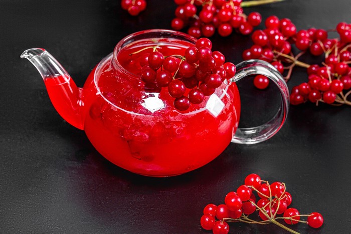 Red viburnum berries in a glass teapot