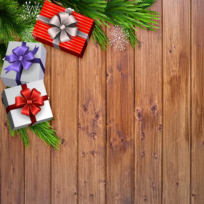 Christmas gifts and pine branches on wood planks