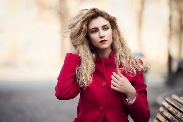 Woman with blonde hair wearing a red coat