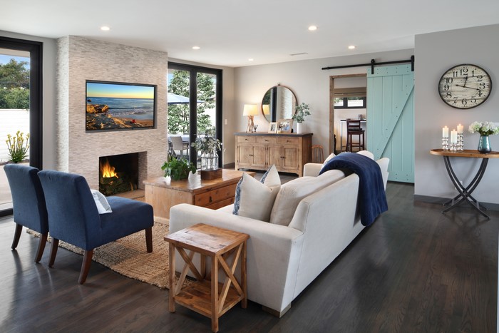 Living room with sofa, armchair, fireplace, and clock