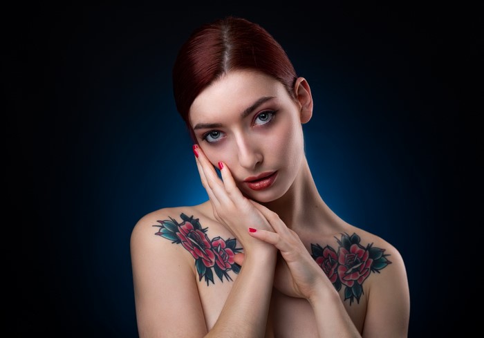 Woman with red hair and rose tattoos