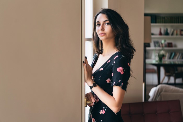 Elegant Brunette Woman in Floral Dress by Window