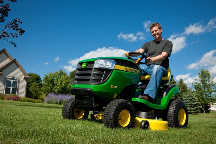 Man on John Deere D110 riding lawn mower
